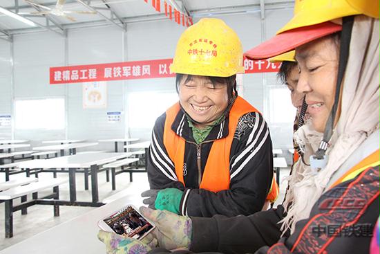 10月18日上午,中国共产党第十九次全国代表大会在北京人民大会堂隆重召开。在这个特别的日子里,中铁十七局集团建筑公司京沈客专辽宁段ZF-1标项目有着13年党龄的农民工党员毛桂英和工友姐妹们一同观看了“十九大”会议直播。图为毛桂英和她的工友姐妹们一边观看习总书记讲话,一边感慨这几年身边的变化。(中铁十七局建筑公司 宗丽丽).JPG